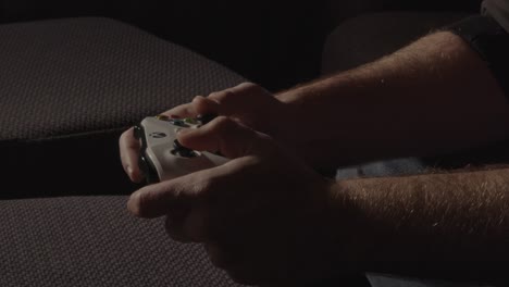 Hände-Spielen-Mit-Einem-Videospiel-Controller-In-Einem-Dunklen-Raum