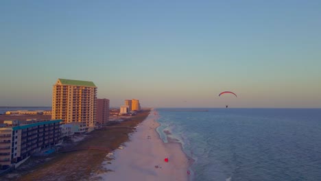 A-paraglider-floats-through-the-sky-over-the-ocean-at-sunset