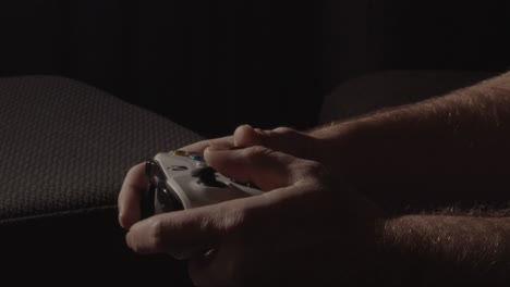 Male-hands-playing-relaxed-on-a-videogame-controller-and-pushing-buttons