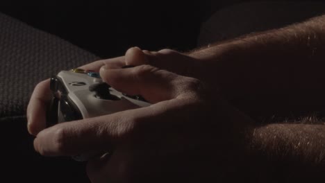close-up-of-hands-playing-frantically-on-a-videogame-controller-in-a-dark-living-room