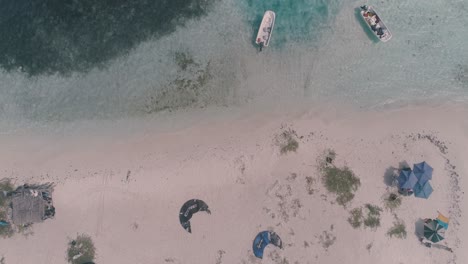 Drone-shot-tilt-up-caribbean-sandbank,-kitesurf-camp-on-white-sand-beach,-saky-saky-Los-Roques