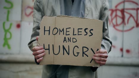 Mann-Hält-Obdachloses-Und-Hungriges-Pappschild,-Obdachloses-Konzept