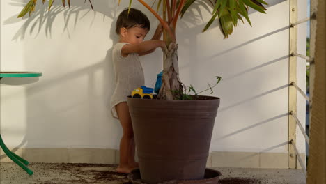 Cute-latin-baby-boy-using-a-blue-toy-broom-to-clean-sweep-the-dirt-from-the-floor-after-doing-a-mischief-on-a-sunny-afternoon