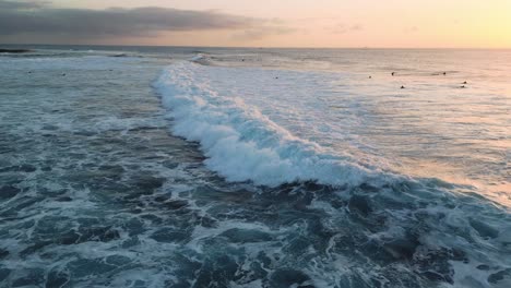 Aerial-view-of-a-breaking-wave-at-sunset
