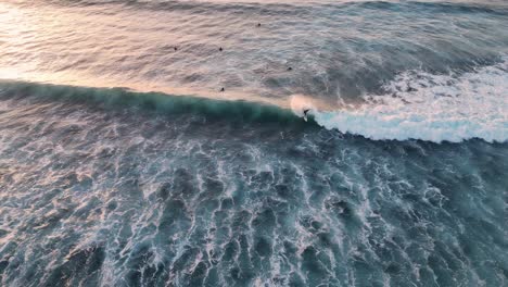 Luftaufnahme-Eines-Surfers,-Der-Bei-Sonnenuntergang-Eine-Welle-Fängt