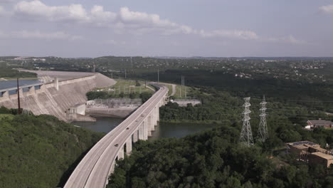 A-sweeping-fly-over-shot-of-a-relatively-empty-freeway-which-sits-adjacent-to-a-water-regulating-dam