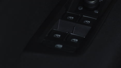 Close-up-pressing-the-up-and-down-window-buttons-on-a-car