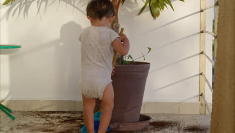 Little-young-latin-toddler-in-a-baby-romper-sweeping-with-a-toy-broom-the-dirt-from-the-floor-after-a-mischief