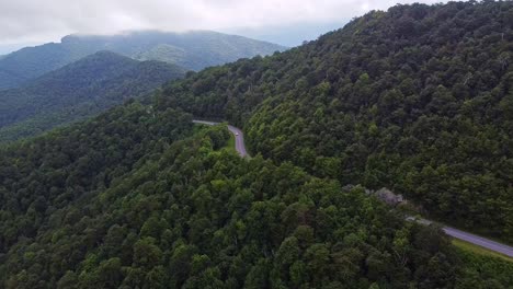 Aerial-view-of-traffic-on-a-mountain-road,-majestic-untouched-natural-environment