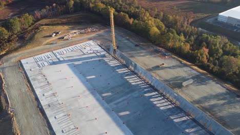 a-corkscrew-drone-shot-of-a-heavy-duty-crane-lifting-a-concrete-panel-into-its-final-resting-place
