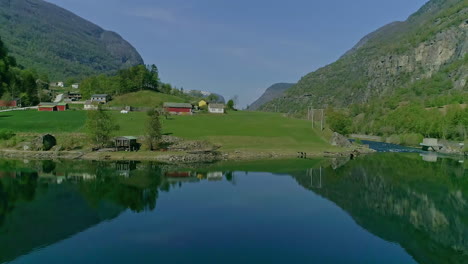 Drone-flying-over-fjord-waters-at-Aurland,-Vestland-in-Norway
