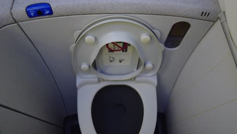 Airplane-bathroom-toilet-with-lid-open-up-down-panning-view