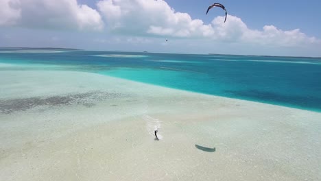 Drone-shot-tracking-man-Kiteboard-AROUNd-SANDBANK-and-TURQUOISE-SEA-WATER,-LOS-ROQUES