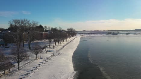 Post-snowfall-winter-drone-shot-flying-over-water
