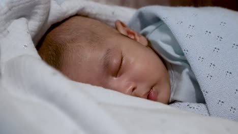 Entzückender-Schlafender-Zwei-Monate-Alter-Indischer-Junge,-Eingewickelt-In-Eine-Blaue-Decke