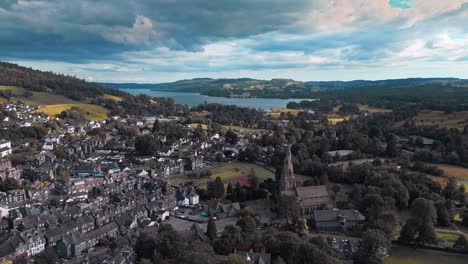 Aerial-footage-of-the-quite-village-of-Ambleside,-moving-slowly-towards-St-Mary’s-Church-and-Lake-Windermere-in-the-distance
