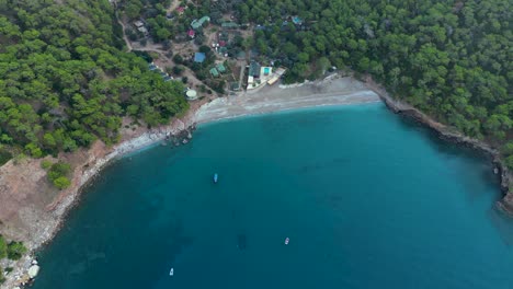 aerial-view-of-a-small-beach-village-in-the-mountains-surrounded-by-mediterranean-sea---Kabak---Turkey