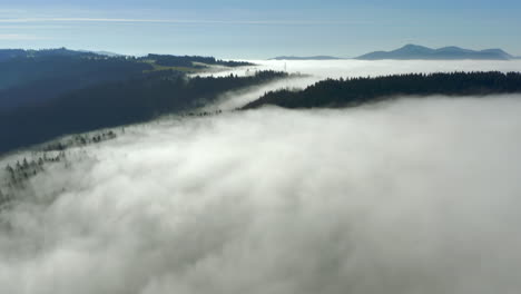 Aerial-hyperlapse-flying-just-above-clouds-over-forested-mountain-peak