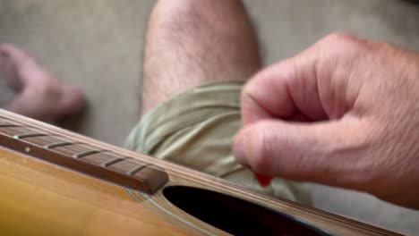 POV-closeup-of-a-mature-man-strumming-an-acoustic-guitar