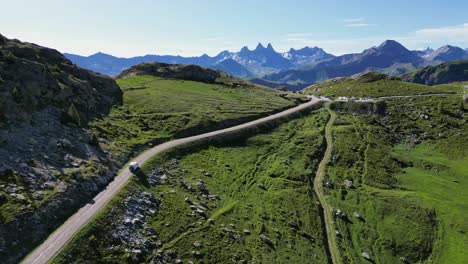 RV-Motorhome-drives-Mountain-Pass-Col-de-la-Croix-de-Fer-in-Savoy-Isere,-French-Alps---Aerial