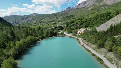 People-hiking-along-turquoise-light-blue-glacial-lake-in-La-Grave---La-Meije,-French-Alps---Aerial-Dolly-Forward