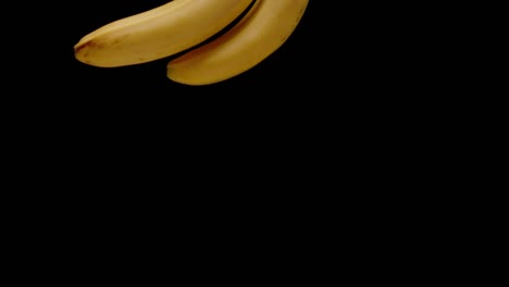 Bündel-Bananen,-Die-In-Zeitlupenansicht-Vor-Schwarzem-Hintergrund-Fallen