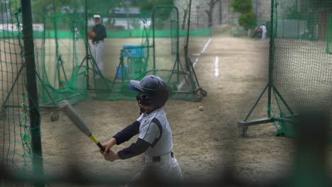 Japanese-kid-hits-the-ball-on-baseball-training,-slow-motion