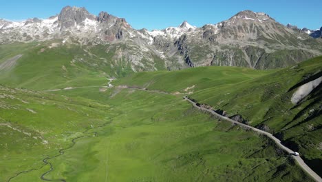 Motorhome-RV-driving-Col-de-la-Croix-de-Fer-Mountain-Pass-in-Savoy-Isere,-French-Alps---Aerial
