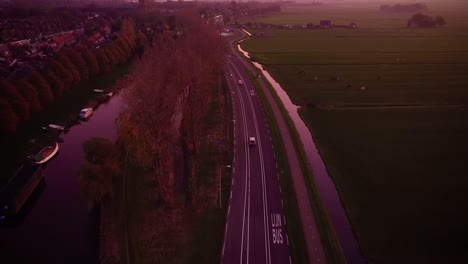 Tiro-De-Drone-De-La-Carretera-En-La-Hora-Dorada-Por-El-Pasto-Verde-En-Amsterdam