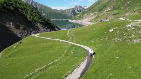 RV-Motorhome-drives-winding-road-to-Lac-de-Grand-Maison-in-French-Alps---Aerial