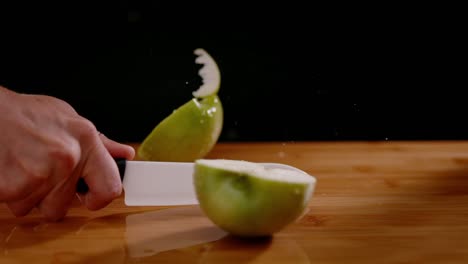 Sharp-knife-cut-wet-apple-in-half-with-power,-slow-motion-view