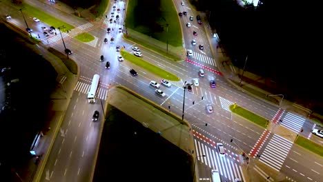 Low-flying-aerial-tilting-shot-of-multi-lane-road-in-modern-city-center-with-skyscrapers-at-night