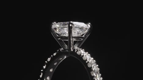 Close-up,-diamond-ring-slowly-rotating-against-black-studio-background