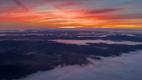Einzigartige-Pilotenperspektive-Aus-Einem-Jet-Cockpit,-Das-Im-Morgengrauen-Mit-Einem-Intensiven-Orangefarbenen-Himmel-Und-Einer-Nebligen-Landschaft-Südwärts-über-Deutschland-Fliegt