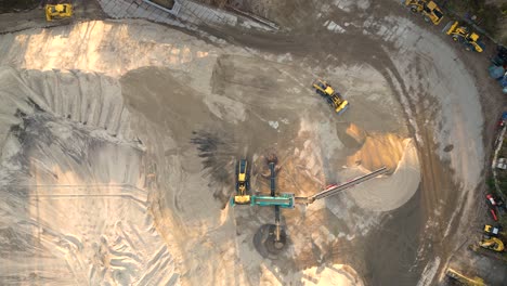 Mining-truck-transporting-sand-at-sand-quarry-aerial-view-of-mining-machinery-moving-at-sand-mine-top-view-of-mining-equipment-at-sand-mine-mining-industry-heavy-vehicle-at-sandpit