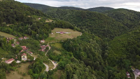 Aerial-View-of-Houses-on-Lush,-Green-Mountain-Slopes,-Dolly-In