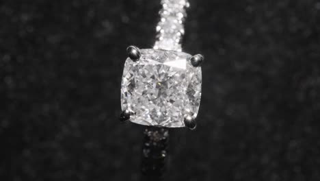 Top-down,-expensive-diamond-engagement-ring-rotating-against-black-background
