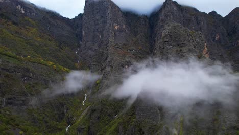 Wolken-Und-Felsige-Berge-Im-Herbst-Mit-Hohen-Gipfeln,-Die-Von-Nebel-Und-Bächen-Bedeckt-Sind
