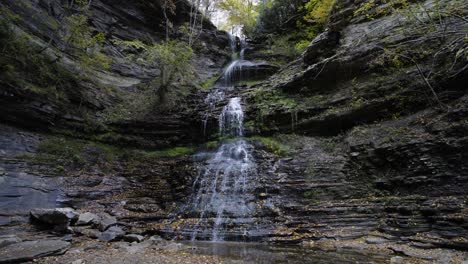 Static-shot-of-a-small-waterfall-at-the-Gorge-river-with-leaves-falling