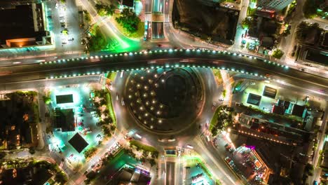 Nächtlicher-Autobahnkreisverkehr-Hyperlapse-Beleuchtet-Mit-Neonfarbenen-Lichtern-Luftautoverkehr-Und-Nachtleben-In-Santiago-De-Chile,-Fliegende-Drohne