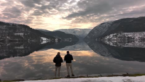 2-friends-looking-out-on-the-magical-reflection-in-the-mountain-lake