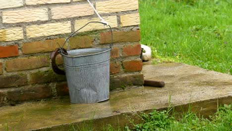Detail-Of-Bucket-From-Water-Well-In-The-Rain,-Europe