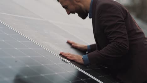 Satisfied-man-in-business-clothes-hugs-and-kisses-solar-panel