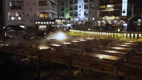 Wooden-channels-carrying-hot-spring-water-source-in-Kusatsu-in-Gunma,-Japan-with-beautiful-light-up-in-the-evening