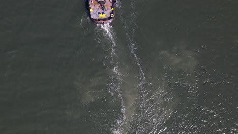 A-top-down,-aerial-view-over-a-tugboat-on-a-sunny-day-in-the-East-Rockaway-Inlet-in-Queens,-NY