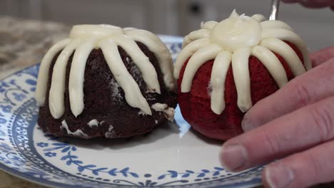 Placing-a-red-velvet-cupcake-on-a-plate-with-a-chocolate-muffin---parallax-motion