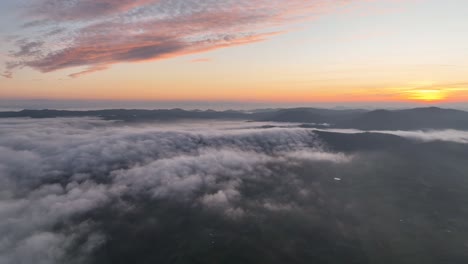 Short-footage-taken-by-drone-flying-above-the-moving-clouds-into-a-beautiful-sunset