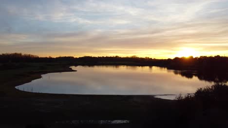 Friedliche-Seelandschaft-Mit-Goldenem-Sonnenuntergang,-Luftdrohnenansicht