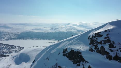 Skiing-down-a-steep-mountain-in-Norway-with-the-fjords-in-the-background