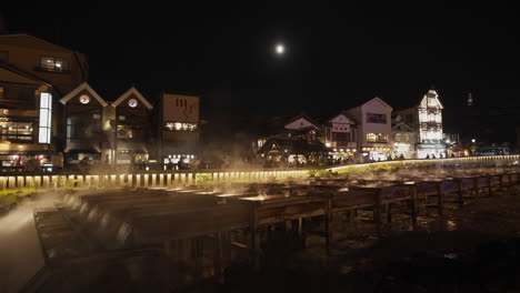 Hot-steam-coming-out-from-the-Yubatake-in-the-evening-after-light-up-in-Kusatsu-Onsen,-Gunma-—-one-of-the-main-sources-of-hot-spring-water-in-the-resort